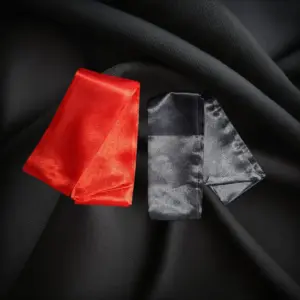 Roter und schwarzer Bondageschal auf schwarzem Hintergrund
