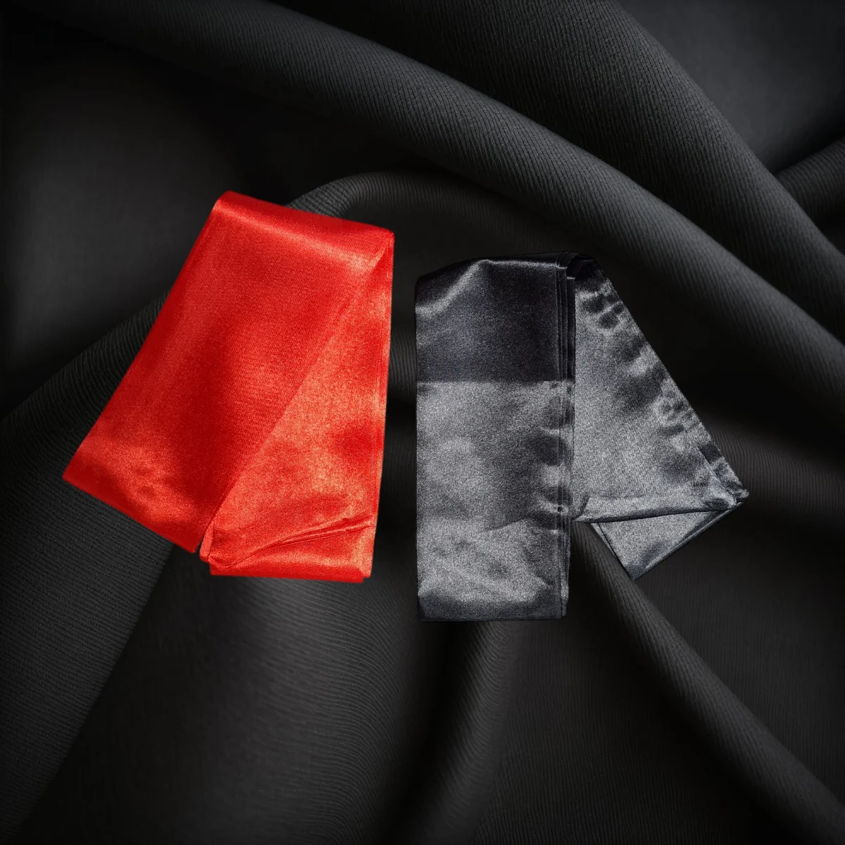 Roter und schwarzer Bondageschal auf schwarzem Hintergrund