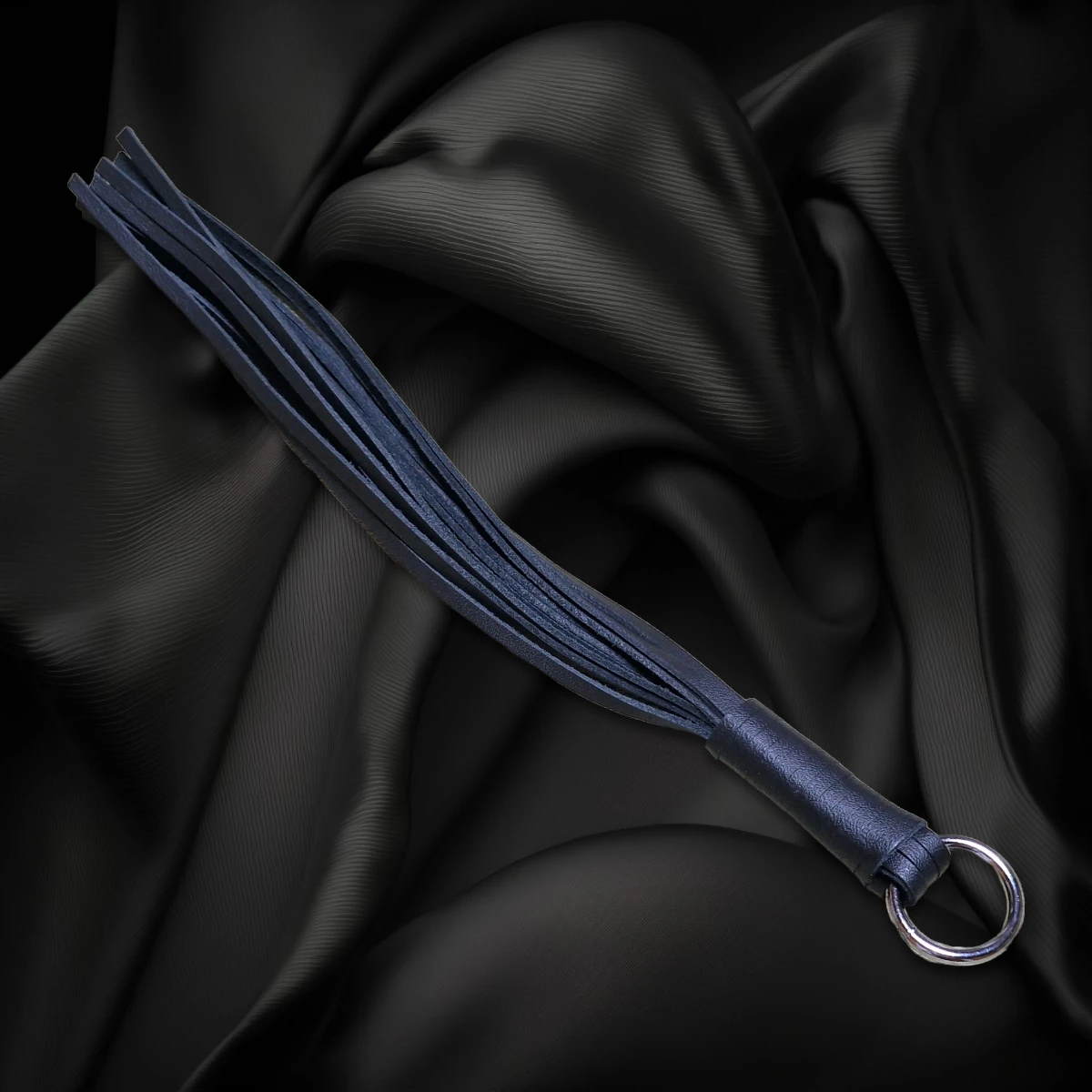 Schwarze Striemenpeitsche mit schwarzem Griff und Metallring