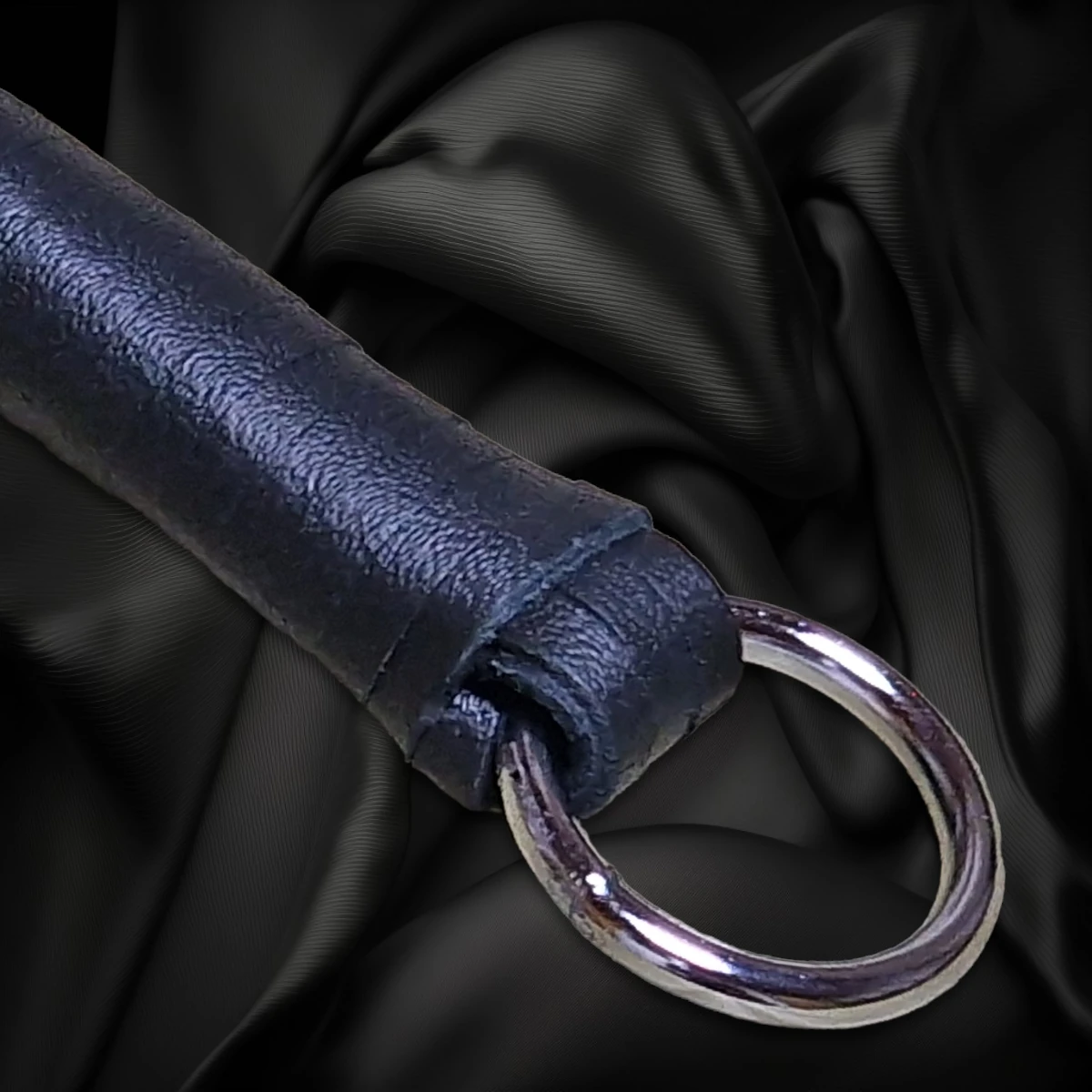 Schwarze Striemenpeitsche mit schwarzem Griff und Metallring