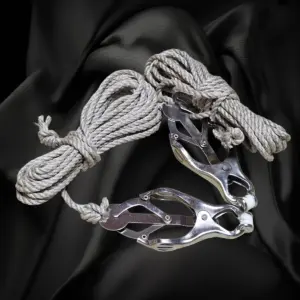 Zwei silberfarbene Metallklemmen mit naturfarbenen Bondageseilen