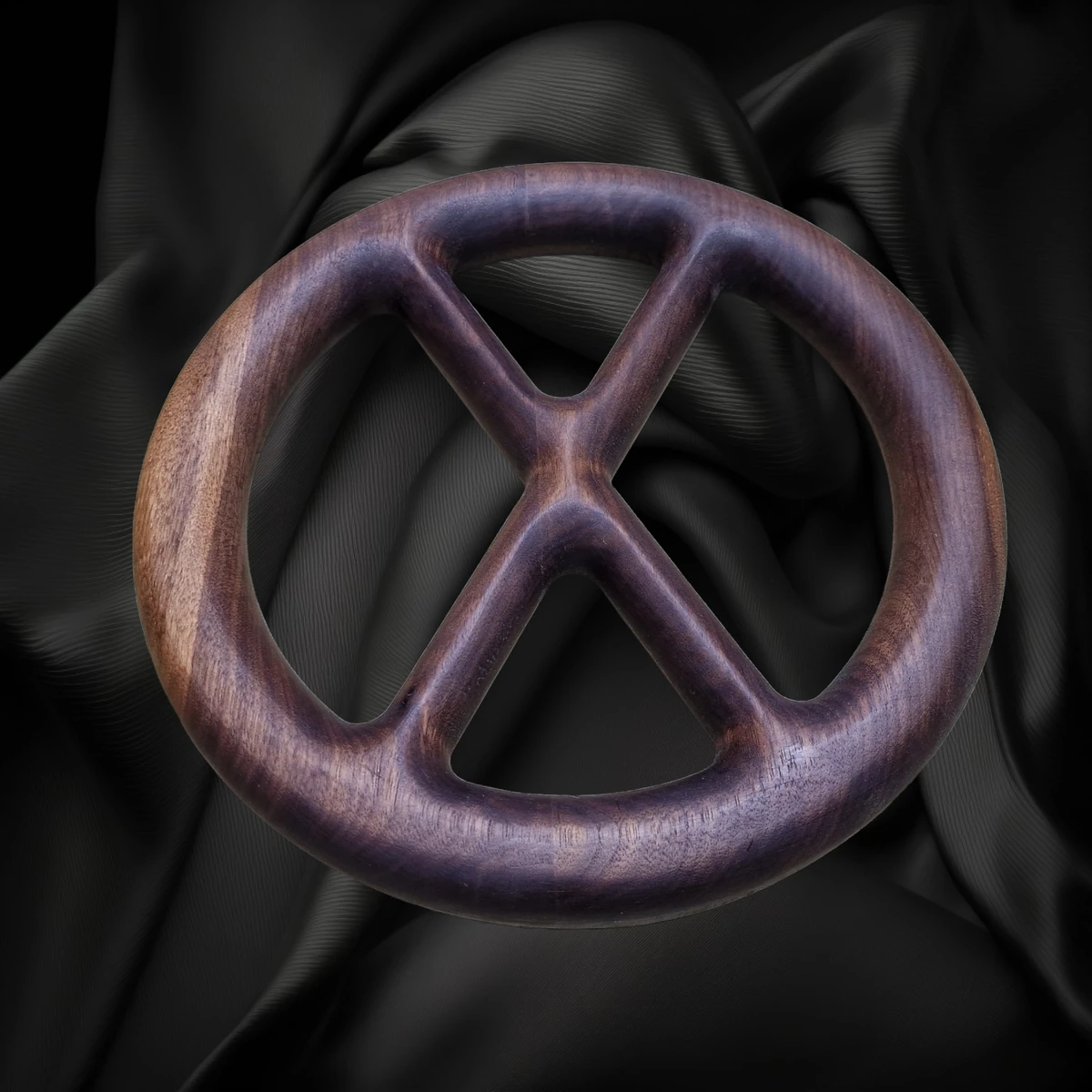 Anillo redondo de madera de nogal con dos puntales interiores cruzados.